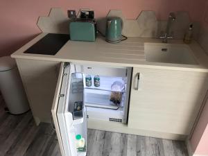 a small refrigerator with its door open next to a sink at Fistral Hideaway in Newquay +7 photos
