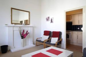 a living room with two chairs and a mirror at Grindlay Street Residence, 2 Bedroom, 2 Bathroom apartment close to Castle in Edinburgh +21 photos