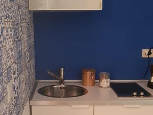- une cuisine avec un évier et un mur bleu dans l'établissement B&B Copacabana Colors, à Margherita di Savoia