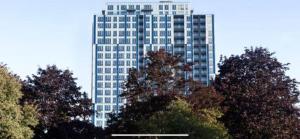 a tall white building with trees in front of it at K D Tower Lux Apartment in Hemel Hempstead