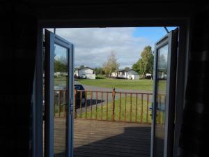 - une porte ouverte sur une terrasse couverte offrant une vue sur la cour dans l'établissement Wentworth view, à Tydd Saint Giles