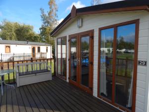 une maison avec une terrasse et des portes en verre dans l'établissement Wentworth view, à Tydd Saint Giles