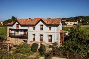 Cette grande maison blanche dispose d'un balcon sur une colline. dans l'établissement La Vega de Pendueles, à Pendueles