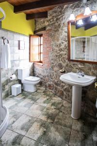 a stone bathroom with a sink and a toilet at La Vega de Pendueles in Pendueles