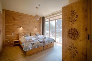 Postel nebo postele na pokoji v ubytování Tatrzańskie Echo Domki Regionalne z dwoma łazienkami, placem zabaw i przepięknym widokiem na Tatry