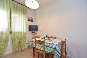 a dining room with a table and chairs and a television at Apartment with nice terrace 684 in Štinjan