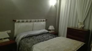 a bedroom with a bed and two night stands and two lamps at Playa y Sol in Cubelles
