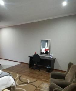 een woonkamer met een bureau en een spiegel bij Tranquil House B&B @ 121 Berry St in Queenstown