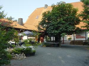 um edifício com uma árvore em frente em ferienwohnungen hottenroth em Warmensteinach