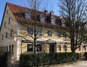 een groot geel huis met een rood dak bij Hotel Gasthof Hainzinger in Einsbach