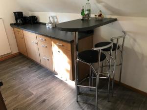 a kitchen with a black counter and two bar stools at Ferienwohnung Schäffer in Regensburg +8 photos