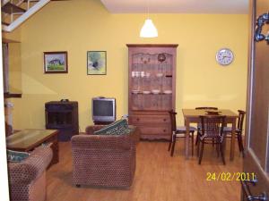a living room with a table and a tv at Apartamentos rurales La Lastra 2 llaves, in Caso
