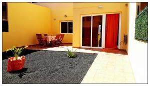 een kamer met een patio met een tafel en een rode deur bij Lur de la playa in Corralejo