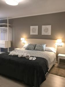 a bedroom with a large bed with towels on it at Apartamento Turístico Puigcerdá Correos in Puigcerdà