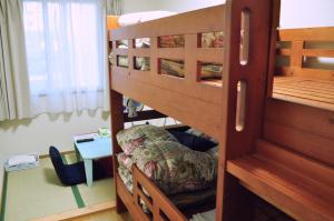 um quarto com 2 beliches e uma mesa em Guest house HiDE em Lago Toya