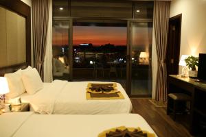 um quarto de hotel com uma cama e vista para a cidade em Moc Tra Hotel Tuan Chau Hạ Long em Ha Long