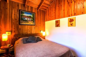 1 dormitorio con 1 cama en una pared de madera en Hotel Mango Valley en Grecia