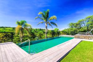 a swimming pool in a villa with palm trees at Hotel Mango Valley in Grecia