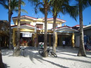 a building with palm trees in front of it at Sulu Plaza in Boracay