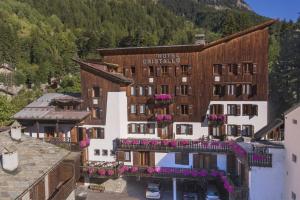 a hotel in the mountains with flowers on the balconies at Hotel Cristallo in Courmayeur