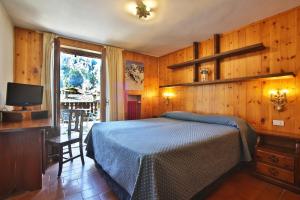 a bedroom with a bed and a television in it at Hotel Cristallo in Courmayeur
