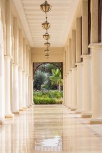 an empty hallway with white columns and a chandelier at Four Seasons Hotel Tunis in Gammarth