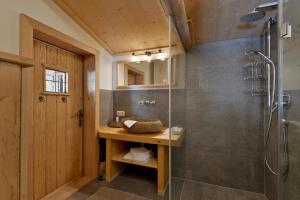 un bagno con doccia e lavandino di Almnest in Hochfügen mit privat SPA a Hochfugen
