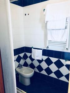 baño azul y blanco con lavabo y aseo en Hotel Elisabetta, en Castellammare di Stabia