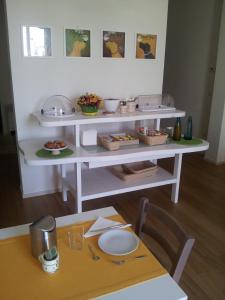 una mesa con un estante con comida. en Alsecondopiano B&B en Gioia del Colle