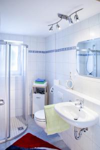 ein weißes Bad mit einem Waschbecken und einem WC in der Unterkunft Ferienwohnungen Tweraser in Bad Birnbach