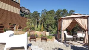 eine Terrasse mit einem Pavillon und Stühlen in der Unterkunft Goda Hotel & Spa in Druskininkai