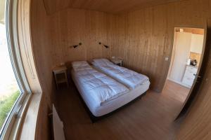 1 dormitorio pequeño con 1 cama en una pared de madera en Myllulækur, en Nesjum