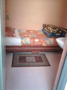 ein Schlafzimmer mit einem Bett, einem Waschbecken und einem Teppich in der Unterkunft Hotel Aday in Marrakesch