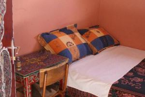 a small bedroom with a bed and a table at Hotel Aday in Marrakech