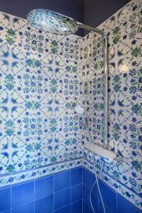 Łazienka z prysznicem wyłożona jest niebieskimi i białymi kafelkami. w obiekcie Donna Filomena Casa Vacanza di Charme w mieście Salerno