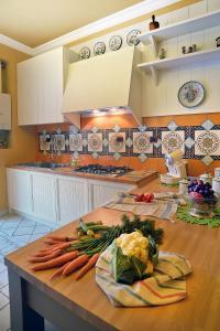 uma cozinha com cenouras e outros vegetais numa mesa em Donna Filomena Casa Vacanza di Charme em Salerno