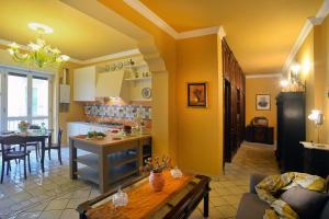 a kitchen and living room with yellow walls and a table at Donna Filomena Casa Vacanza di Charme in Salerno