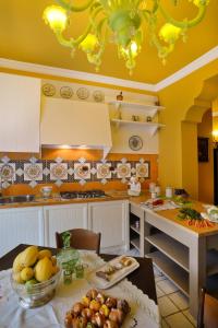 a kitchen with yellow walls and a table with food on it at Donna Filomena Casa Vacanza di Charme in Salerno