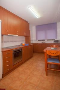 a large kitchen with wooden cabinets and a table at Beatiful holiday flat in Galicia with sea views and next to the "Camino de Santiago" in Estorde
