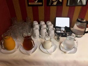 a table topped with cups and pitchers of tea on plates at Film Hotel in Bratislava