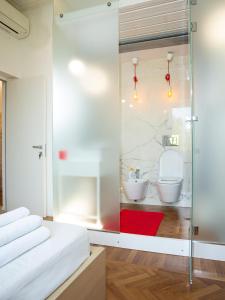 ローマにあるルーム イン ローマ イソレのガラスの壁の客室で、バスルームが備わります。