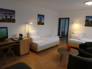 salon z 2 łóżkami i telewizorem w obiekcie Hotel Restaurant Felderbock w mieście Nußloch