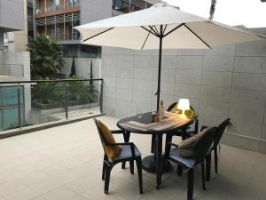 d'une table, de chaises et d'un parasol sur le balcon. dans l'établissement Loft with terrace 24m2, swimming pool and garage, à Chirivella