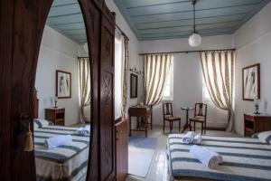 A bed or beds in a room at Nostos Guesthouse