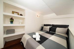 sypialnia z czarno-białym łóżkiem i półkami w obiekcie Suite Rodinò w mieście Napoli