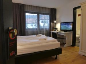 a bedroom with a bed and a desk with a computer at Hotel Restaurant Felderbock in Nußloch