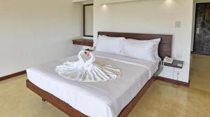 dos cisnes blancos sentados en una cama en un dormitorio en Grand Beach, en Wadduwa