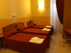 una camera d'albergo con due letti e asciugamani di Hotel Cherubini a Roma