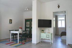 a living room with a table and a tv at Herberge Hof Armada in Wiesbaden