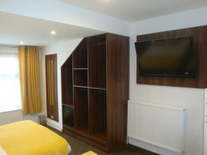 a bedroom with a bed and a flat screen tv at The Sandhurst Hotel in Blackpool